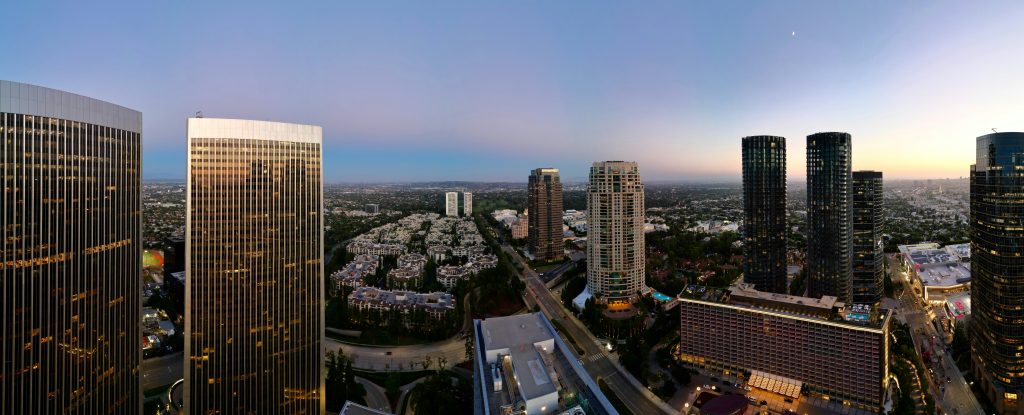 Century City office towers rising above surrounding Los Angeles neighborhoods at dusk