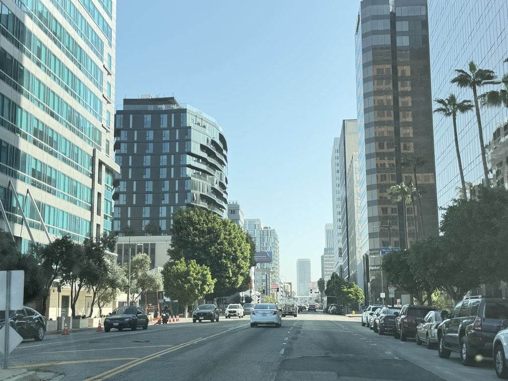 Electric scooters lined up for rent on a Los Angeles sidewalk, showing a common car-free transportation option in LA